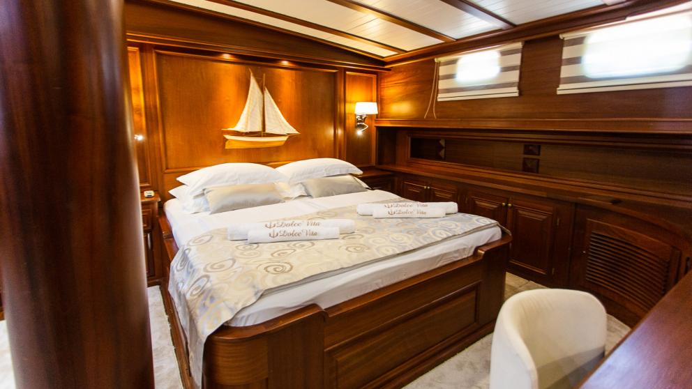 Schlafzimmer mit großem Bett und Segelbootbild an der Wand mit Arbeitsbereich